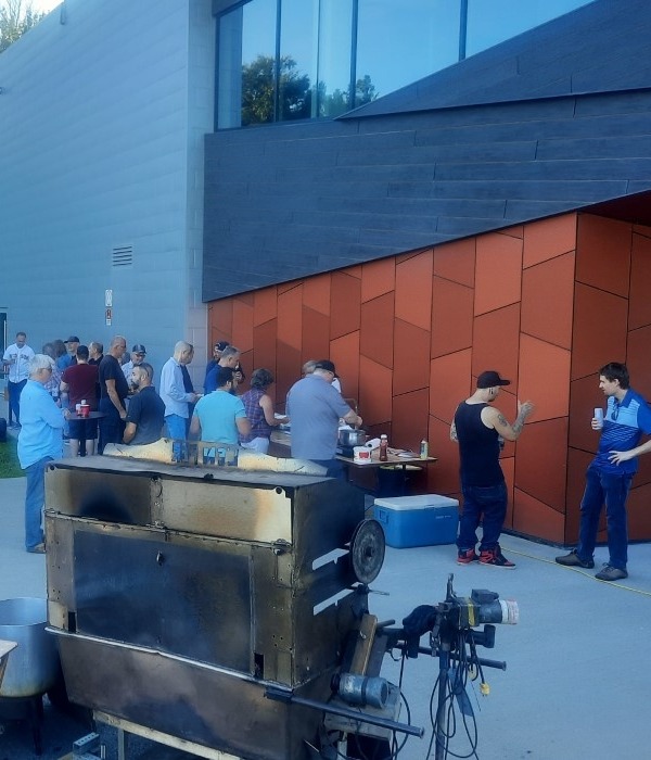 Service traiteur méchoui pour évènement d'entreprise au Québec avec cuisson des viandes au feu de bois d'érable, repas corporatif en plein air par Méchoui du Marquis.